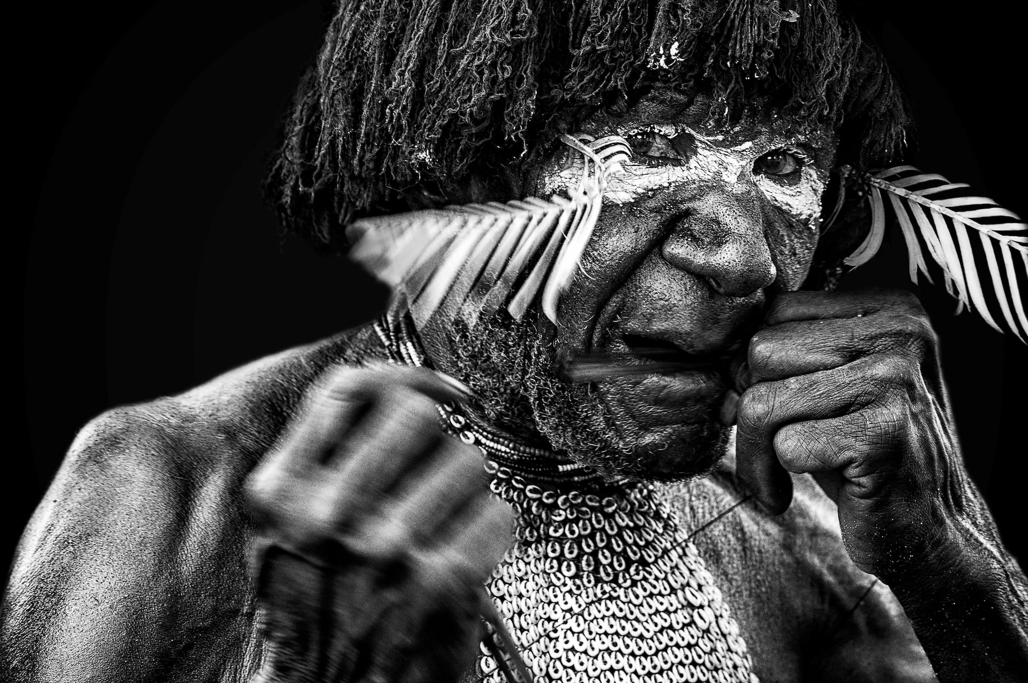 black and white image of a native person with white paint on his eyes