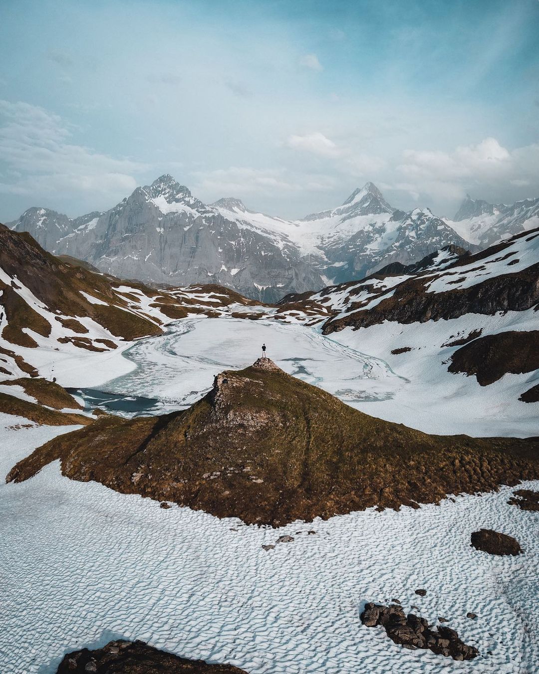 Image of a Man in a vast landscape of mountains covered in snow in Switzerland