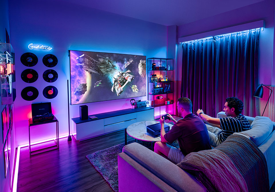 Gamers enjoying a cinematic gaming experience with a projector.