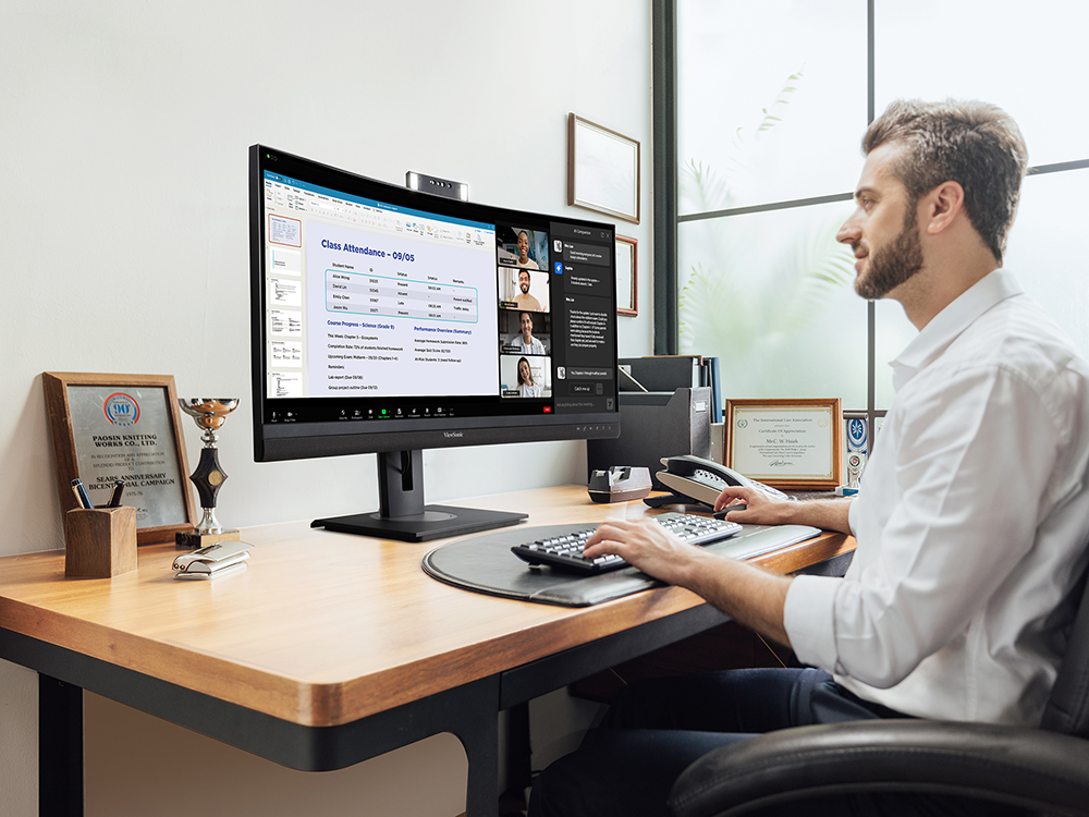 University staff member working at a desk with a ViewSonic ultrawide curved monitor