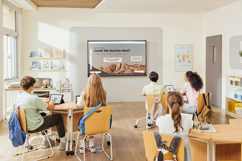 Students in a classroom looking at ViewBoard interactive display on wall.