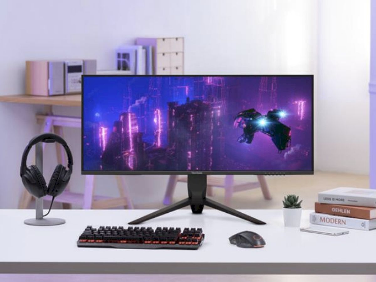 Modern íróasztal-elrendezés egy ultraszéles monitorral, amelyen neonfényes cyberpunk-jelenet látható, így ideális a magával ragadó játékhoz és a kreatív munkához.