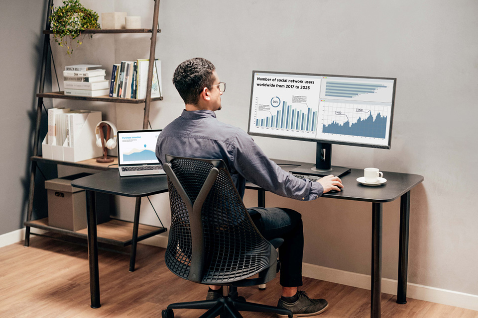 Man die grafieken analyseert op een ViewSonic ultrawide monitor.