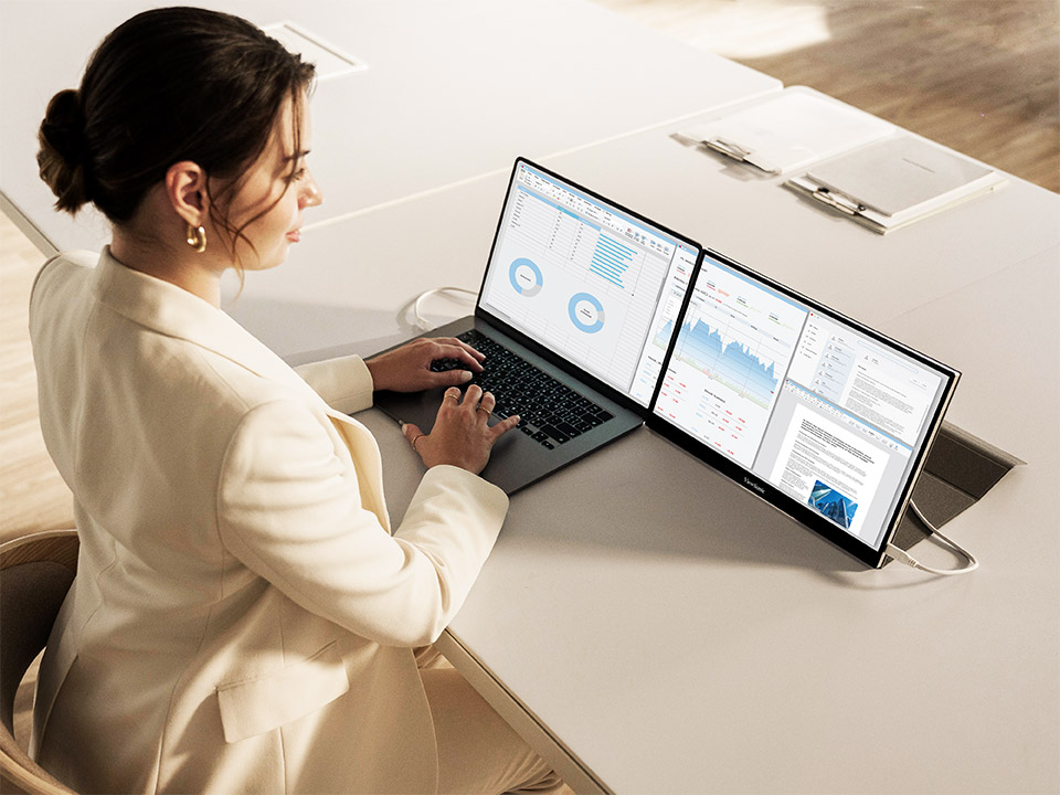 Professional using dual-screen setup to maximize productivity remotely.