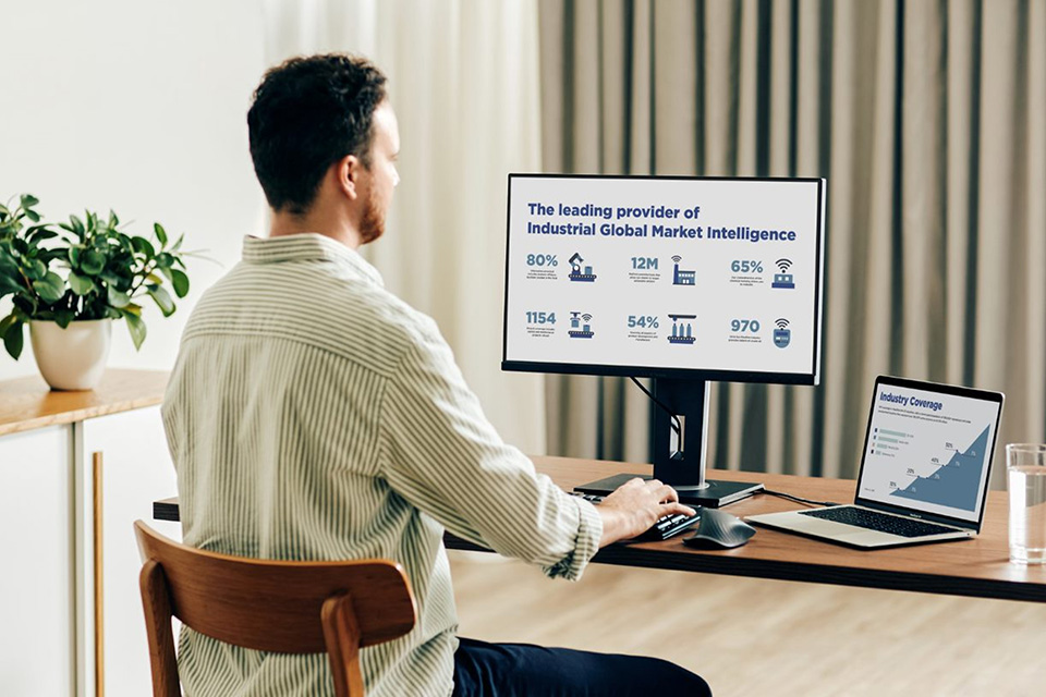 Bărbat care lucrează la un laptop conectat la un monitor ViewSonic.